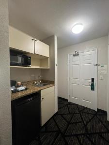 a small kitchen with a sink and a door at Quality Inn & Suites Loveland in Loveland