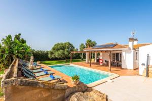 a swimming pool with lounge chairs and a house at Bell Veure in Ciutadella