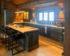 a large kitchen with a large island in the middle at Log Cabin With Views Over Turufjell in Flå