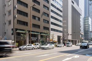 大阪市にあるAIROSE Yodoyabashiの車が停まる賑やかな街道