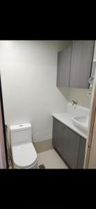 a bathroom with a white toilet and a sink at Unit A-1607 Style Residences in Iloilo City