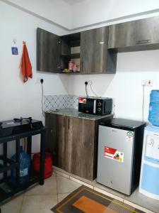 una cocina con encimera con microondas y nevera en Cozy haven kitengela, en Kitengela 