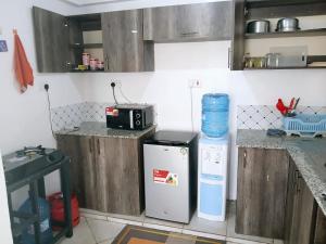 cocina con nevera pequeña y microondas en Cozy haven kitengela, en Kitengela 