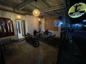 a motorcycle parked in a room with a sign at Tomo Homestay in Ngasinan