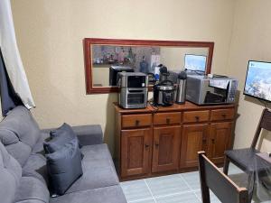 a living room with a couch and a microwave at COP 30 Belém comfy private room in Benevides