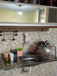 a kitchen sink with a faucet and dishes at COP 30 Belém comfy private room in Benevides