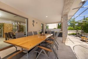 a dining room with a wooden table and chairs at Villa Divina in Milohnići +42 photos