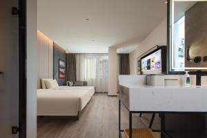 Ένα ή περισσότερα κρεβάτια σε δωμάτιο στο Atour Hotel Jinhua Railway Station Guzicheng