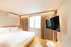 a hotel room with a bed and a flat screen tv at Ulsan Mugeo E'ser Hotel in Ulsan