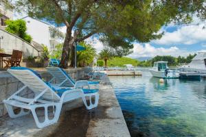 a group of chairs sitting next to a body of water at Apartments Matijasevic in Korčula
