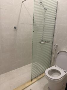 a bathroom with a toilet and a glass shower stall at شقة بغرفة نوم وصالة - Luxury bedroom and living Room in Jeddah