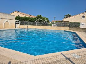 a large swimming pool with blue water at La Marina in Saint-Cyprien-Plage