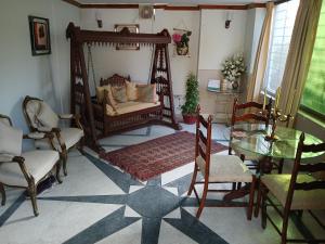 Una sala de estar con una cama, una mesa y sillas. en Room at khan house, en Islamabad