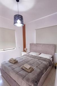 a bedroom with a large bed with two towels on it at Spacious 2 BR appartment near mall -Internet 1Gbps in Paphos City +37 photos