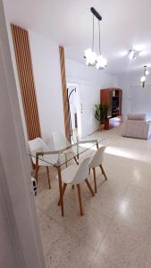 a living room with a glass table and white chairs at Spacious 2 BR appartment near mall -Internet 1Gbps in Paphos City