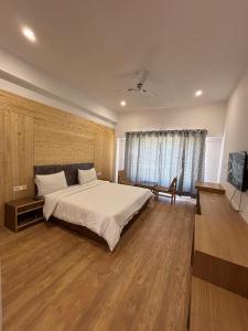 a bedroom with a large bed and wooden floors at Rezangla Hotel in Leh