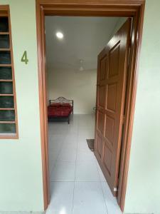 a hallway with a door and a bed in a room at Motel Santai Bandar Pekan in Pekan