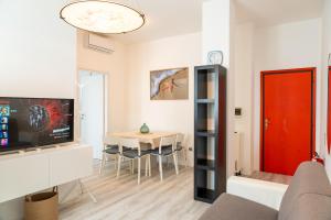 a living room with a red door and a table at Accesso al mare, residence perseo in Lido Adriano