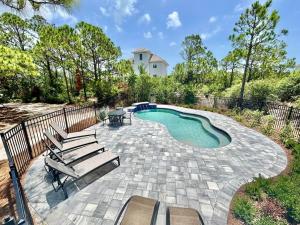a patio with chairs and a swimming pool at Somehow, Someday, Somewhere, Seaside in St. George Island