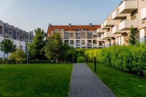 a brick walkway in front of a large building at Osiedle Szafirowe Chic Apartment by BookingHost in Suchy Las