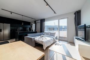 a living room with a couch and a tv at Osiedle Szafirowe Chic Apartment by BookingHost in Suchy Las