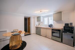 una cucina con un tavolo e un piano di lavoro di Love Room 91 avec Jacuzzi XXL - 15min Orly - 30 min Paris a Longjumeau