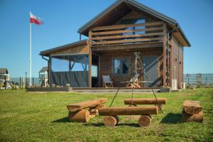 a log cabin with a swing in front of it at Domki Białoławki in Kwik