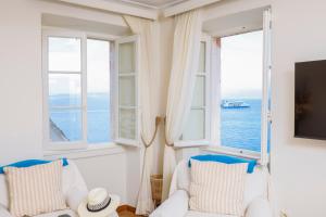 a living room with two white chairs and a large window at Ruby's Gem Corfu in Corfu Town