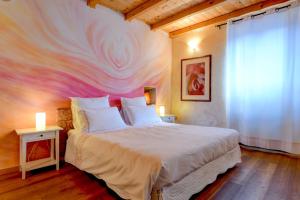 a bedroom with a bed with a painting on the wall at Regina del Lago in San Michele