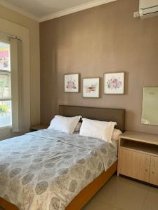 una camera con un letto e tre immagini sul muro di Gandaria Villa Batu a Batu