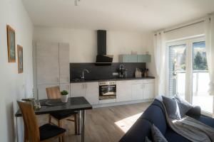a kitchen and living room with a couch and a table at Appartement am Hostertberg 1 in Simmerath