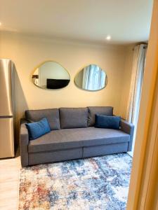 ein Wohnzimmer mit einem Sofa und 2 Spiegeln in der Unterkunft Aisiki Stays Apartments at Colindale, Ground Floor, 2-Bedroom & 1-Bathroom, Pet-Friendly, with Free Wi-Fi and Parking Space in Colindale
