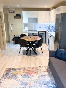 eine Küche mit Tisch und Stühlen in einem Zimmer in der Unterkunft Aisiki Stays Apartments at Colindale, Ground Floor, 2-Bedroom & 1-Bathroom, Pet-Friendly, with Free Wi-Fi and Parking Space in Colindale