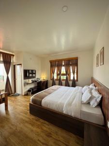 a bedroom with a large bed and a desk at Fratelli Guest House in Shillong +121 photos