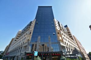 a tall building with glass windows on a city street at Avenue apartments in Yerevan