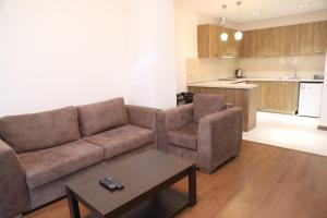 a living room with a couch and a table and a kitchen at Avenue apartments in Yerevan