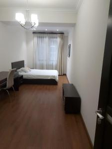 a bedroom with a bed and a desk and a table at Pink Yerevan apartments in Yerevan