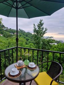 a table and chairs on a balcony with an umbrella at Green Hill in Batumi