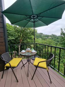 a table and chairs on a deck with an umbrella at Green Hill in Batumi