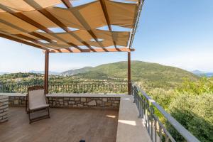 d'un balcon avec une chaise et une vue sur les montagnes. dans l'établissement Odyssey's Palace - Escape in Mythical Ithaca, à Platithriás