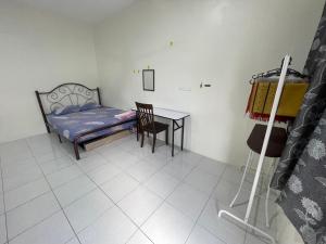a bedroom with a bed and a table and a chair at Bilik Rehat Aircond Pekan in Pekan +7 photos