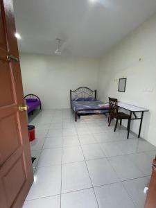 a room with a table and a bed and a desk at Bilik Rehat Aircond Pekan in Pekan