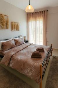 ein Schlafzimmer mit einem großen Bett, auf dem Handtücher liegen in der Unterkunft ΖoiHouse in Polykárpion