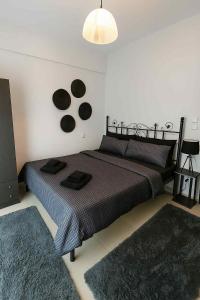 ein Schlafzimmer mit einem Bett und zwei Teppichen an der Wand in der Unterkunft ΖoiHouse in Polykárpion + 12 Fotos