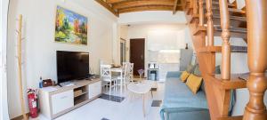 ein Wohnzimmer mit Couch und Fernseher und eine Treppe in der Unterkunft Aigaiou House 2 in Thessaloniki