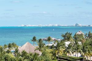 a view of a beach with palm trees and the ocean at CARlBE Beachfront 2BDR with pool by Casa Paraiso in Cancún