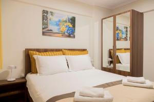 ein Schlafzimmer mit einem Bett, auf dem zwei Handtücher liegen in der Unterkunft Aigaiou House 2 in Thessaloniki