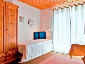 a bedroom with a blue chair and a window at Studio "Renner" in Les Crosets