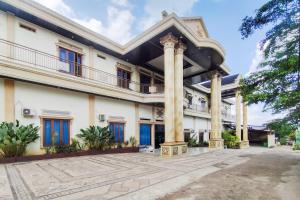PaalmerahRedDoorz near Islamic Center Jambi的建筑外景,带柱子