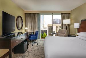 a hotel room with a bed and a desk with a computer at Courtland Grand Hotel, Trademark Collection by Wyndham in Atlanta